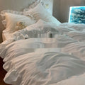 Mori style solid colour washed linen four-piece bedding set on a bed, showing quilt cover, sheet, and pillowcases.