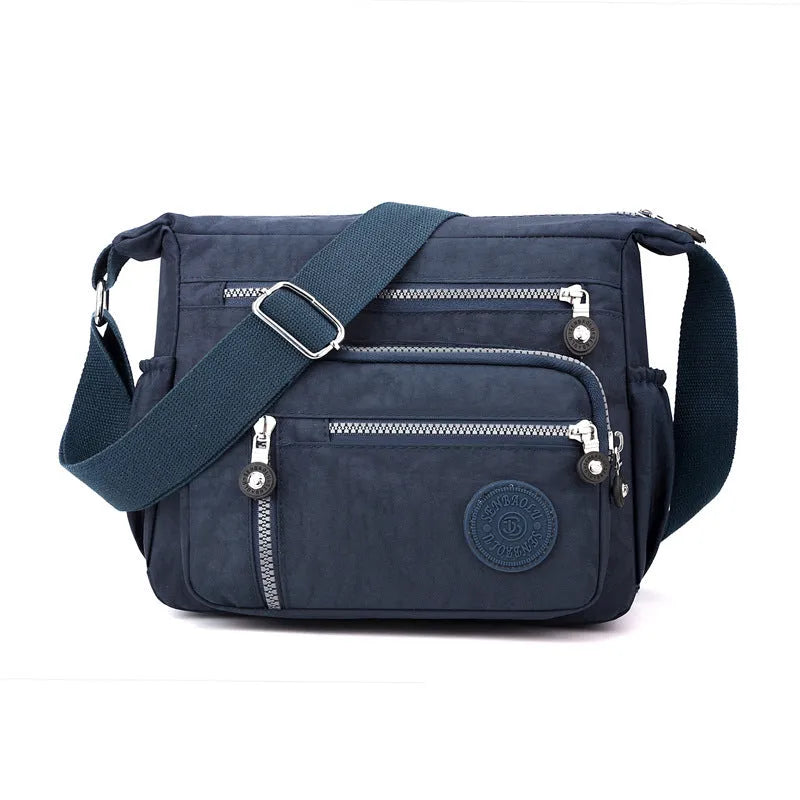 Soft nylon messenger bag in square vertical shape with an adjustable shoulder strap.