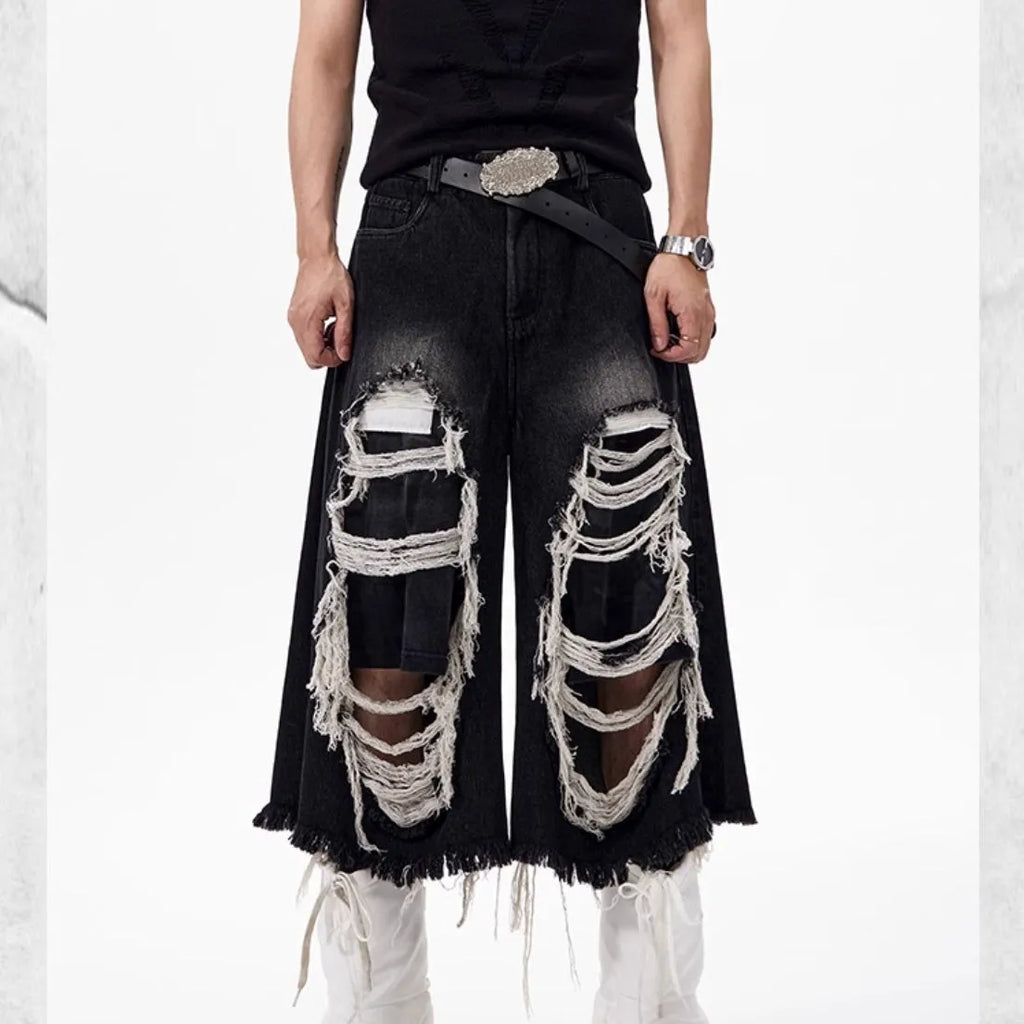 Black wide leg cropped jeans with mid-high waist and ripped patch detail on the legs.