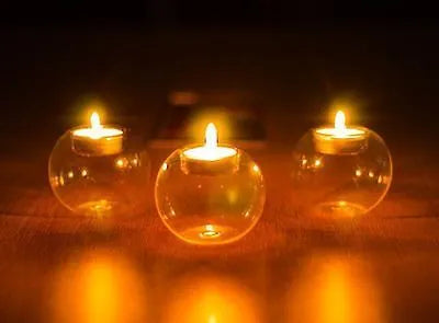Handmade clear hollow glass spherical candle holder in European style on a table.