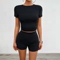Women's solid colour slim-fit two-piece sports set with short-sleeved T-shirt and elastic waist shorts.