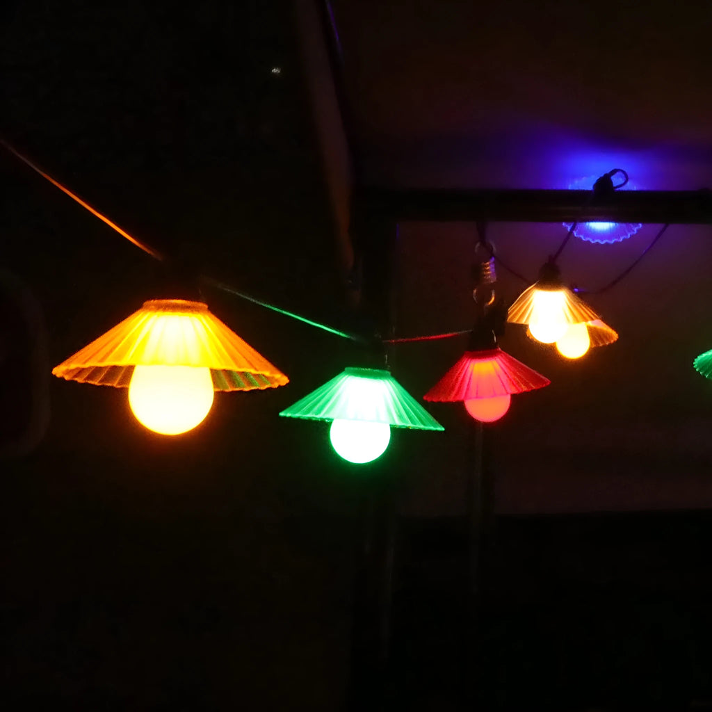 Outdoor LED string lights with flower-shaped globes, showing IP65 waterproof rating and 5V low voltage operation.