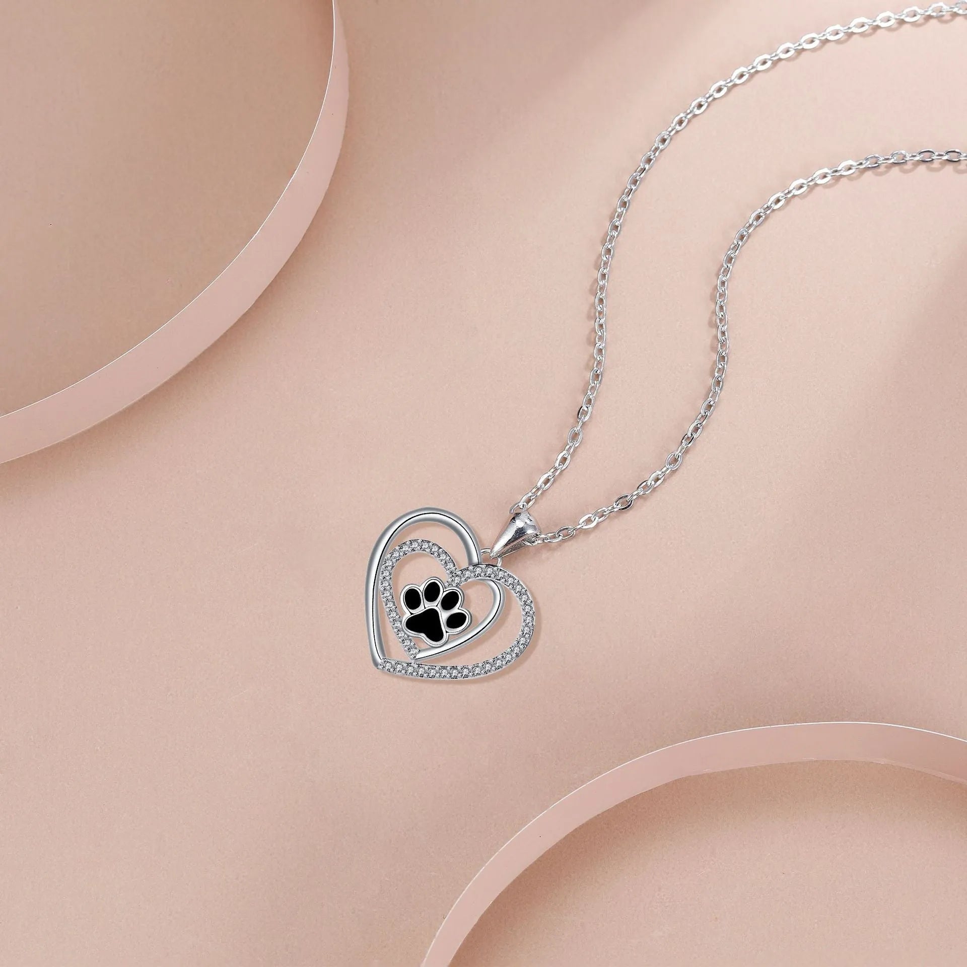 Women's necklace with a copper dog paw print heart pendant on a cross chain.