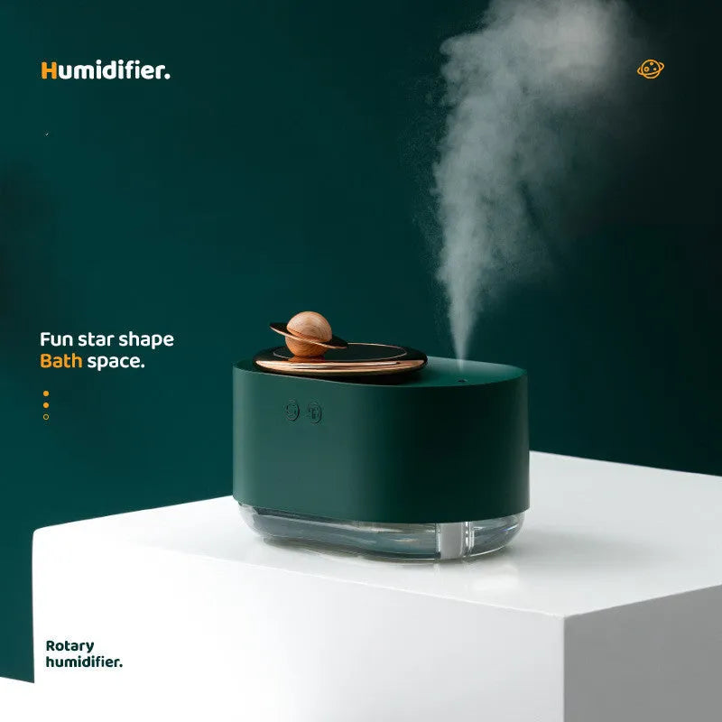 Green rotating planet humidifier with USB charging port and night light on wooden surface