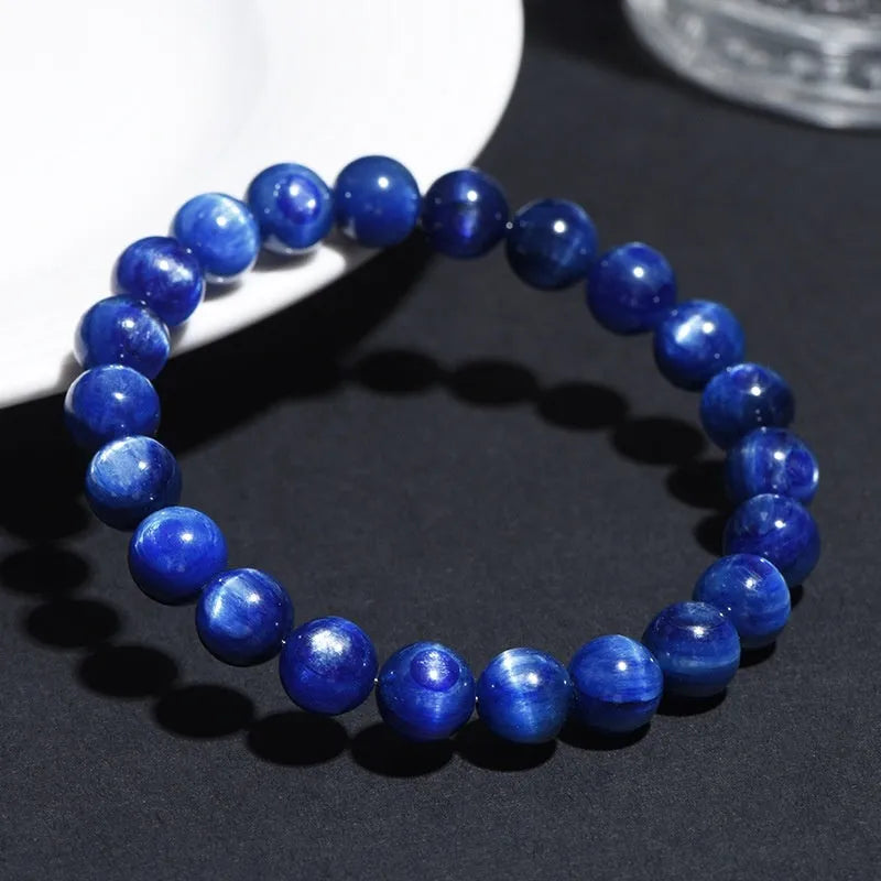 Polished blue crystal ball bracelet with geometric beads and Ruyi design on a white background.