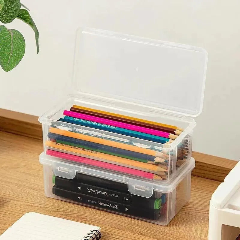 Clear plastic pencil storage box showing coloured pencils and drawing tools inside.