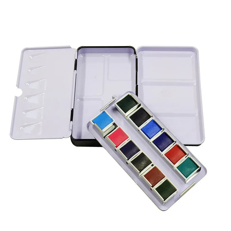 Tinplate metal empty paint box for solid watercolour pigments, shown closed.