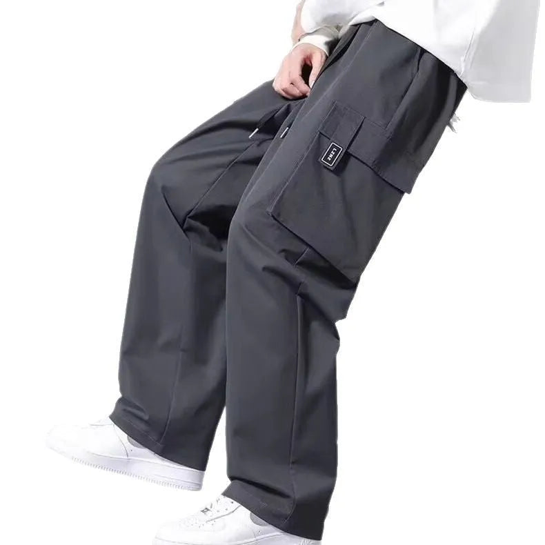 Boy wearing straight leg cargo pants with drawstring waist and large side pockets in army green.