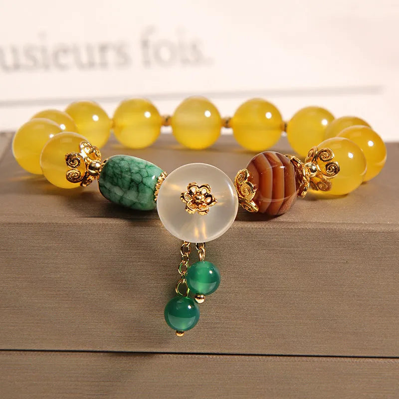 Women's khaki yellow agate crystal bracelet on a gold silk cord.