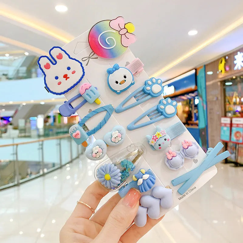 14-piece set of colourful toddler hair clips with candy, fruit, rainbow, and butterfly designs on a white background.