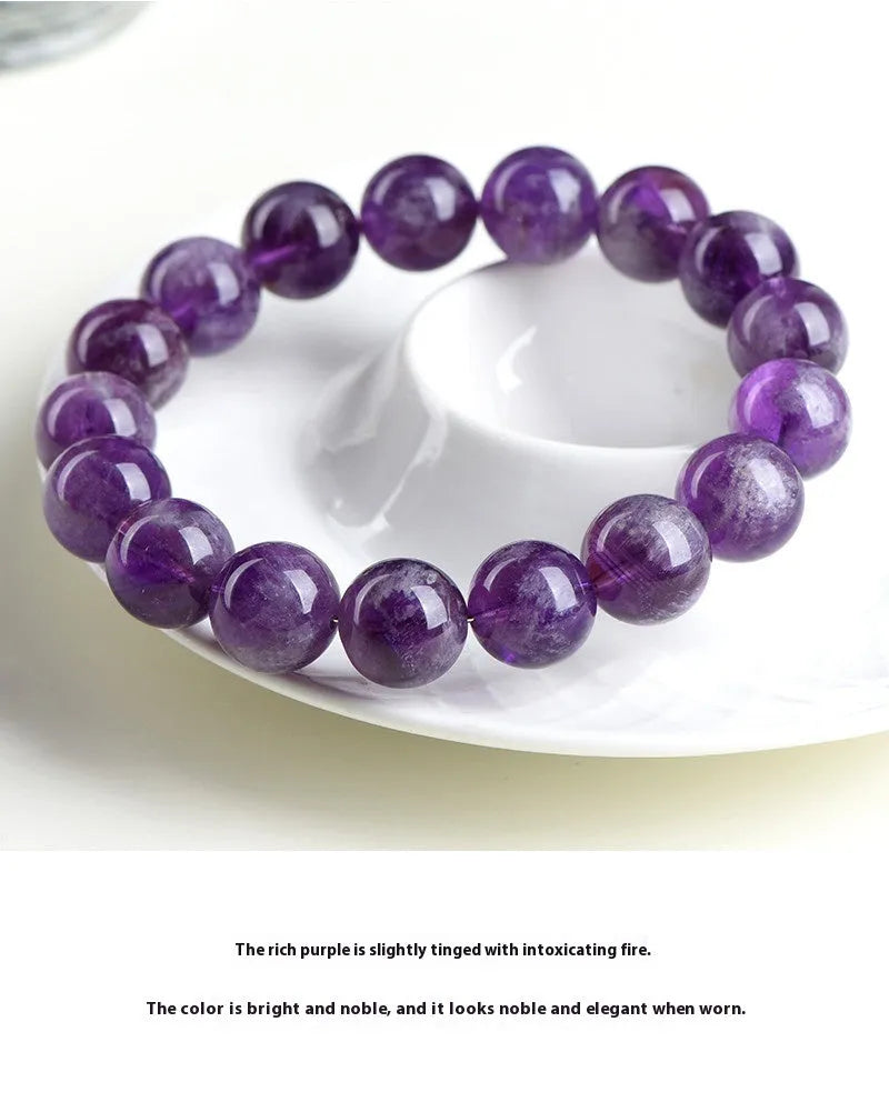 Natural feather amethyst purple crystal bracelet with geometric beads and Ruyi symbol on a white background.