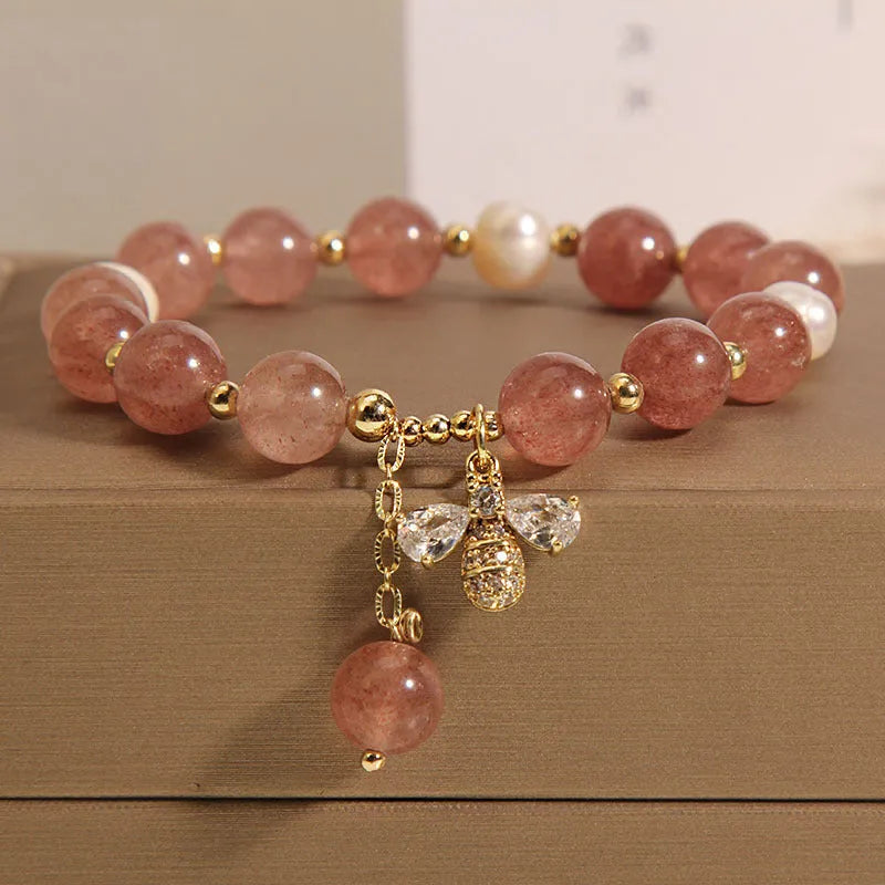 Women's bracelet with three freshwater pearls, a pink strawberry quartz charm, and sparkling zircon stones on an alloy chain.