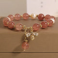 Women's bracelet with three freshwater pearls, a pink strawberry quartz charm, and sparkling zircon stones on an alloy chain.