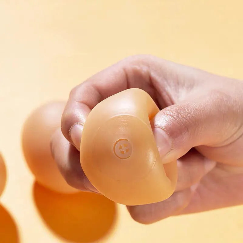 White plastic egg-shaped dog toy with textured surface for tooth cleaning and sound features