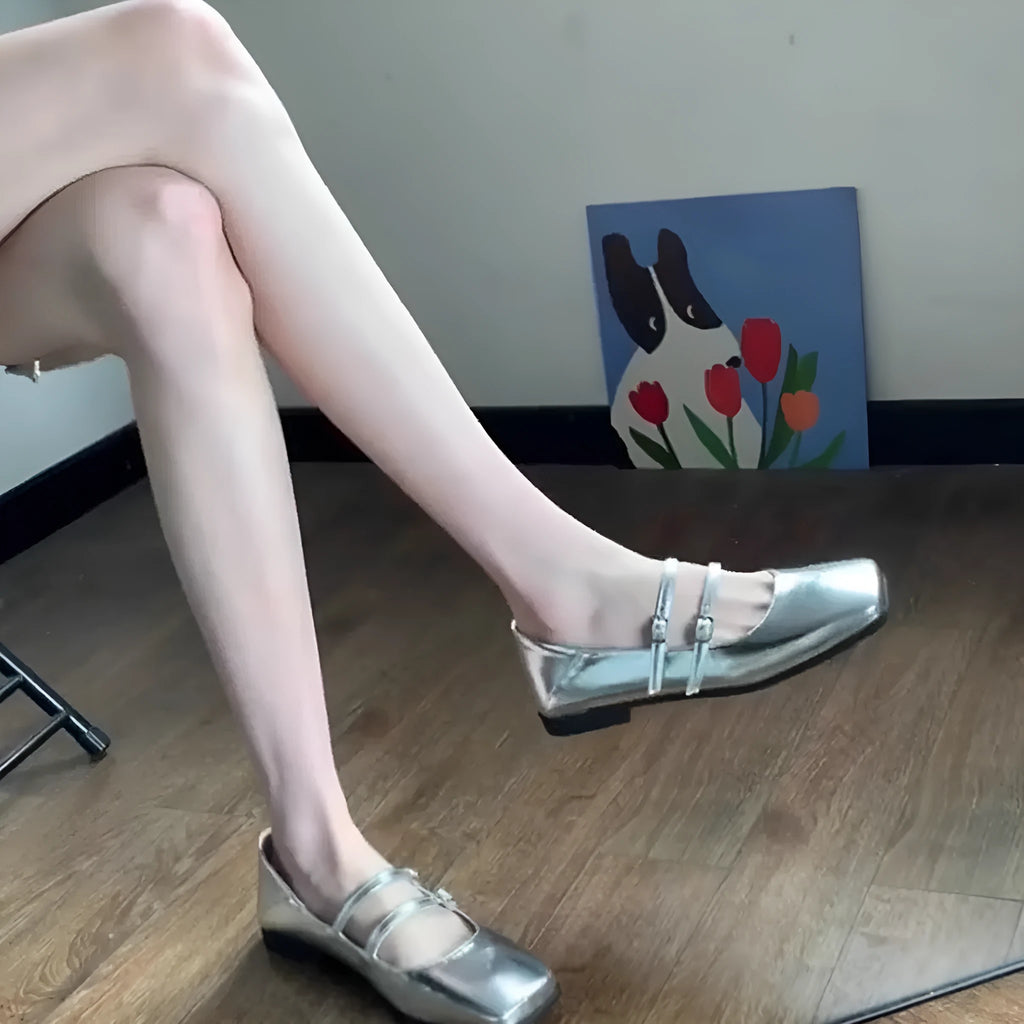 Women's silver genuine sheepskin leather ballet pumps with a cross buckle strap and flat low heel.