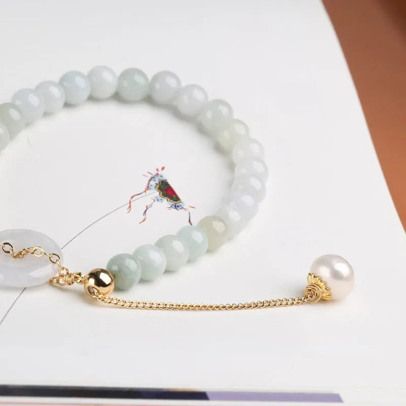 Natural emerald green jade and pearl bracelet with a geometric peace buckle clasp.