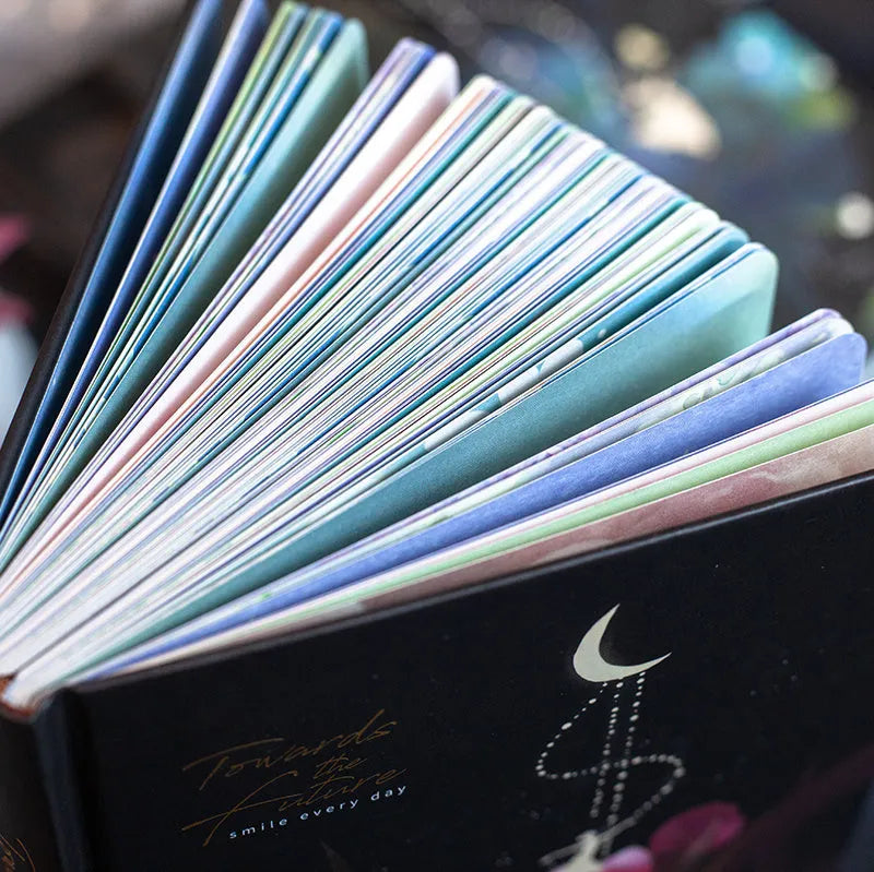 A5 notebook with luminous blue cover open to show colour illustration pages inside