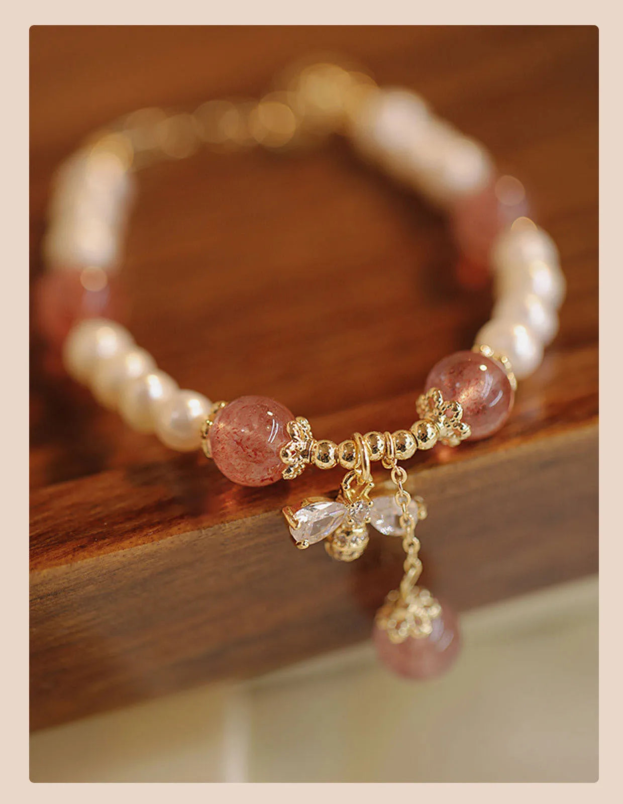 Women's strawberry quartz crystal bracelet with bow clasp closure on wrist