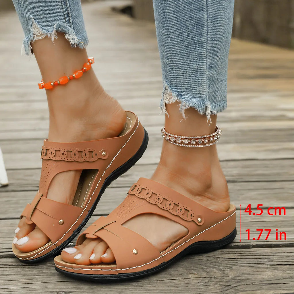 Blue casual slippers with a fish mouth toe holder and slope heel on a wooden floor.