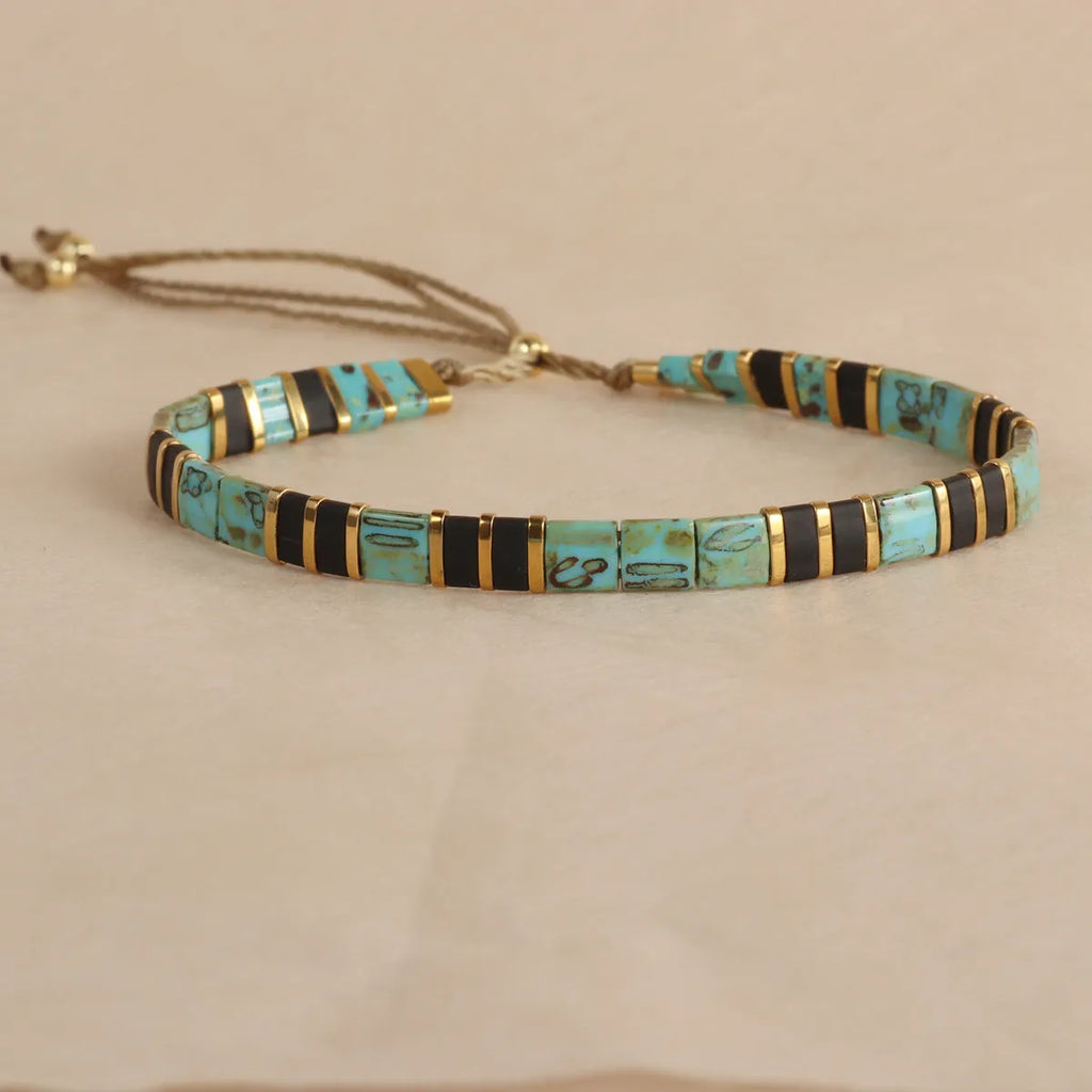 Geometric glass bead bracelet with pull beads design on a wrist, shown in milky white colour.
