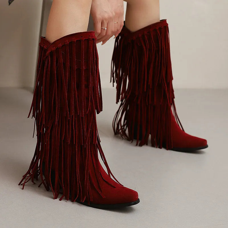 Women's beige suede high boots with tassel detail and a chunky rubber sole.