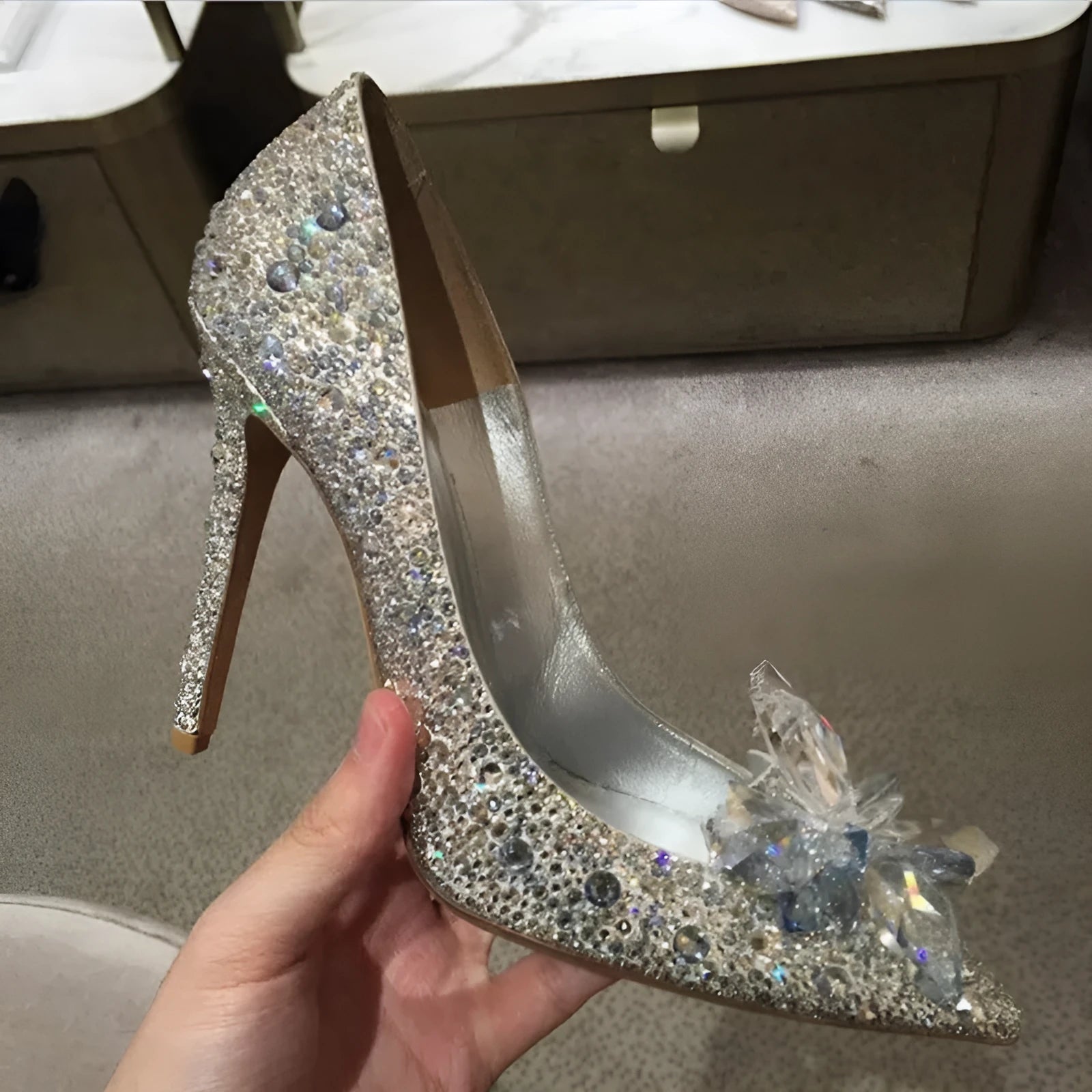 Gold women's pointed toe high heels with rhinestones and a stiletto heel on a white background.