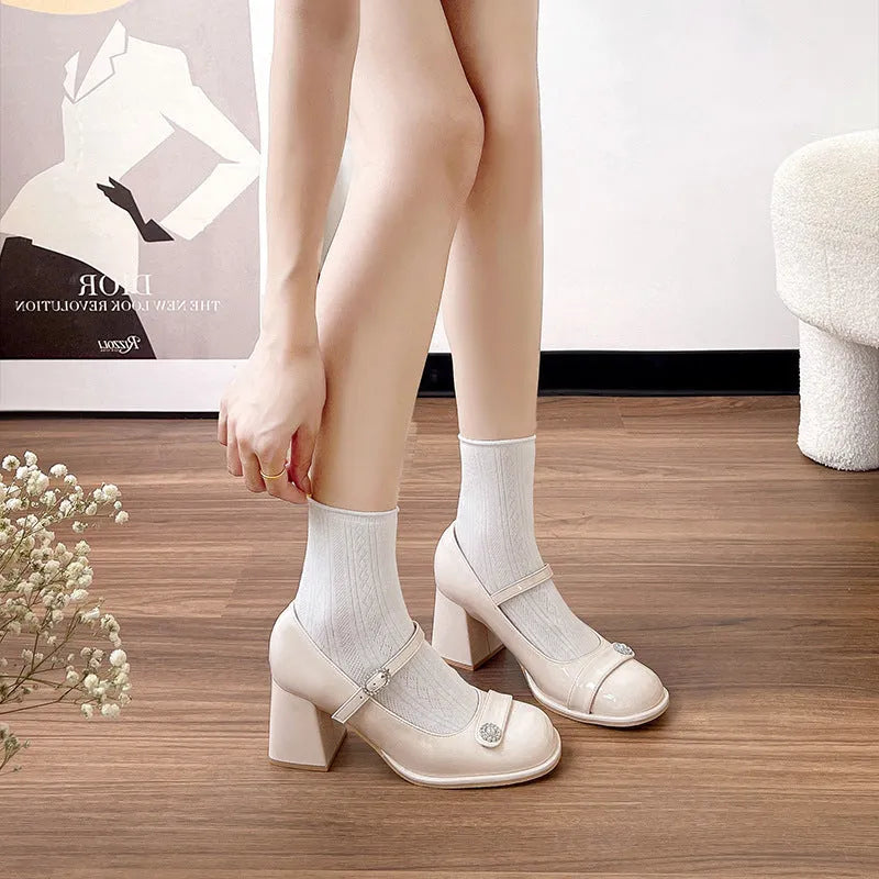 Women's black patent leather chunky heel round toe high heels with ankle buckle.