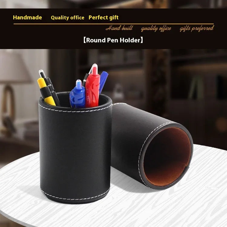 Round black leather pen holder container on desk with pens inside