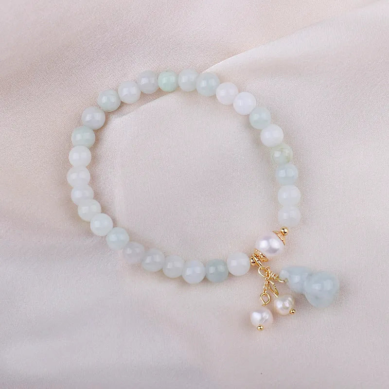 Close-up of a natural emerald jade bracelet with a handcrafted gourd design in Chinese style.