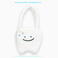 White plush tote bag with large cute teeth graphic, showing crossbody strap and zip opening.