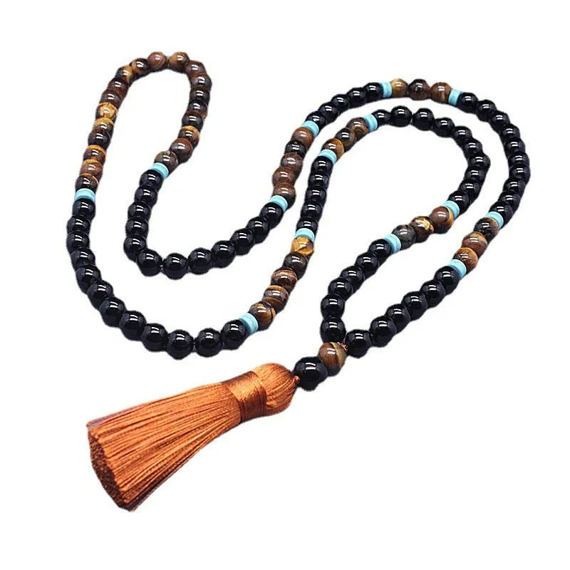 Close-up of black agate and tigereye geometric bead bracelet and necklace set on neutral background