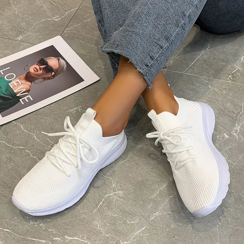 Women's mesh running shoes in creamy white with flat rubber sole and low-top design
