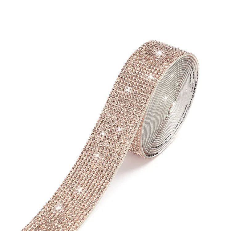 Self-adhesive water drill strip for clothing decoration in white and AB colour on a fabric background.