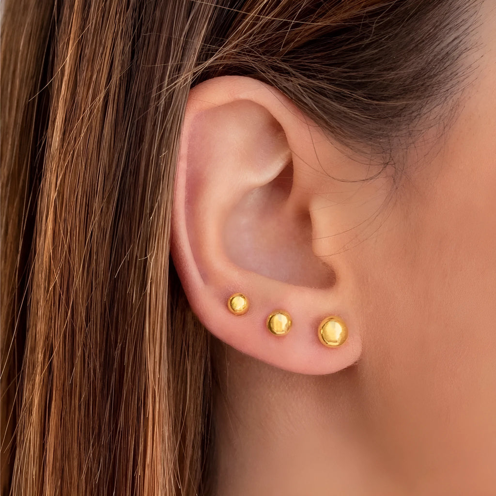 Stainless steel round ball stud earrings on a plain background, showing gold and silver tone options.