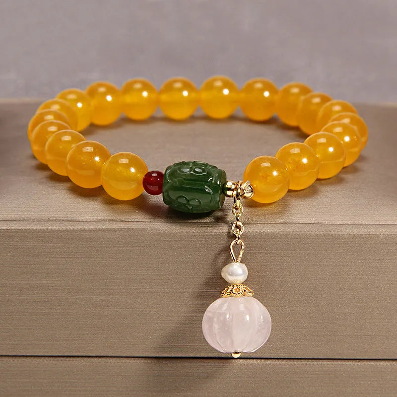 Women's khaki yellow agate crystal bracelet on a gold silk cord.
