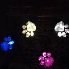 Solar-powered bear paw print garden lights showing four connected lamps and solar panel pole