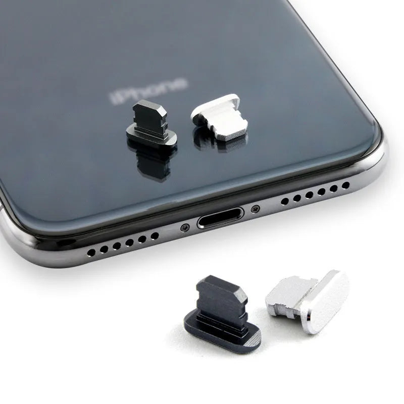 Aluminium alloy iPhone charging port dust plug in metallic colours on a dark background.