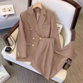 Women's loose-fit polyester blouse in beige, shown on a hanger.