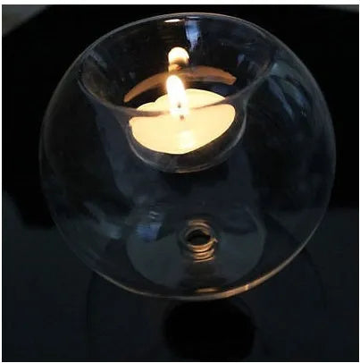 Handmade clear hollow glass spherical candle holder in European style on a table.