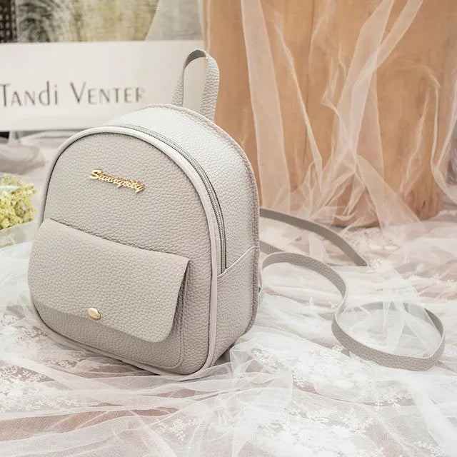 Small black PU women's backpack purse shown as a shoulder bag, with zipper closure and compact size.