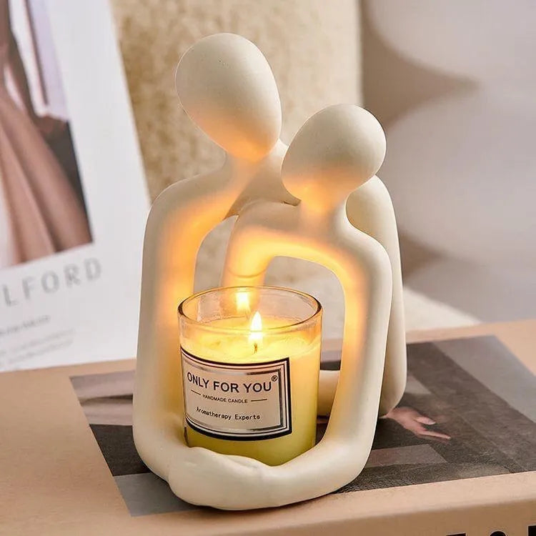 Modern milky white resin statue of a loving couple on a wooden desk.
