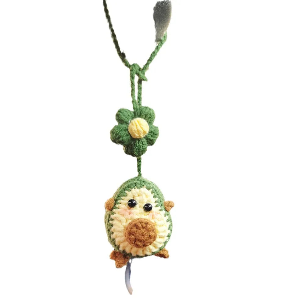 Handmade crocheted wool car pendant shaped like a cartoon avocado with a rainbow flower decoration.