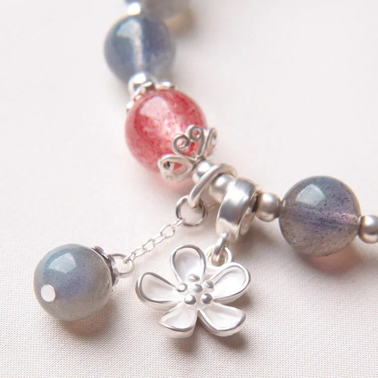Silver grey women's bracelet with honeysuckle pattern, moonlight crystals, and a small zodiac charm.