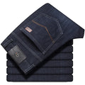 Men's black stretch denim jeans showing loose straight-leg fit with mid waist and zip fly detail