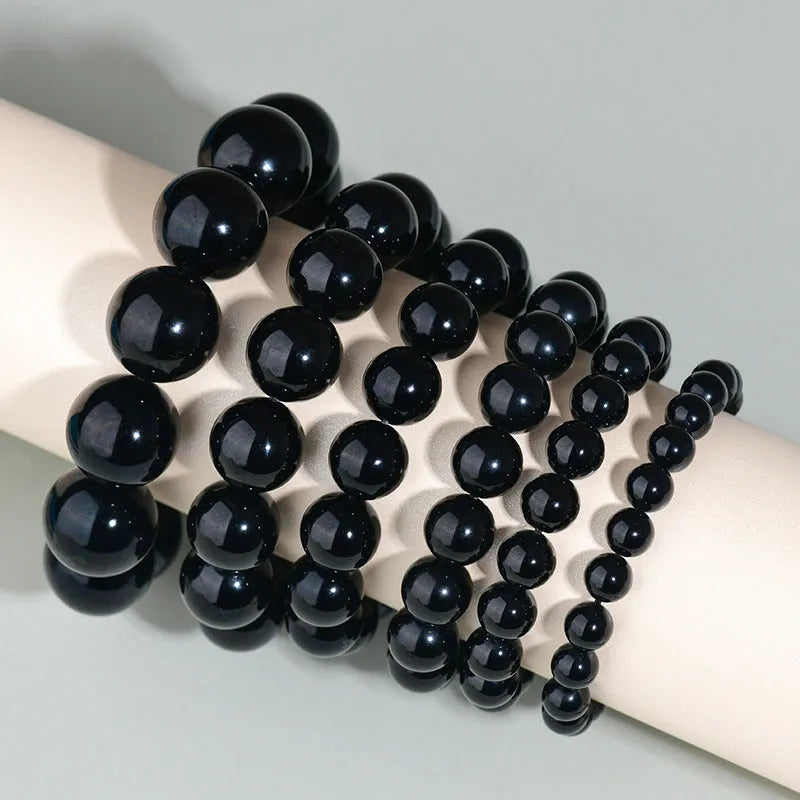 Hand-woven black obsidian bracelet showing round crystal beads in 8mm to 16mm diameter options with ethnic unisex styling