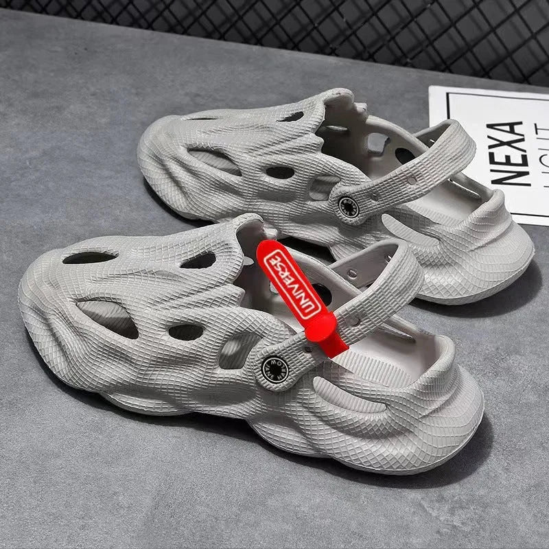 Pair of grey EVA foam closed-toe slippers on a sandy beach
