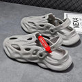 Pair of grey EVA foam closed-toe slippers on a sandy beach
