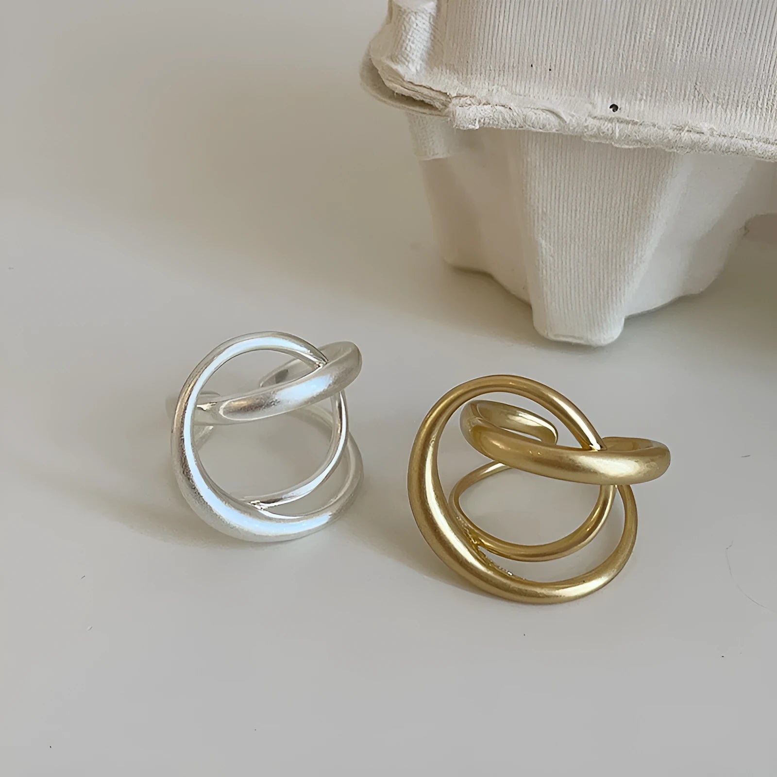 Geometric open ring for women with a three-dimensional interlaced design in matte metal.