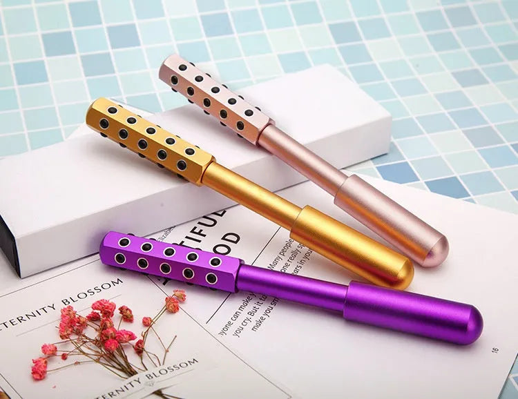 Purple handheld germanium particles facial massage roller on a white background.