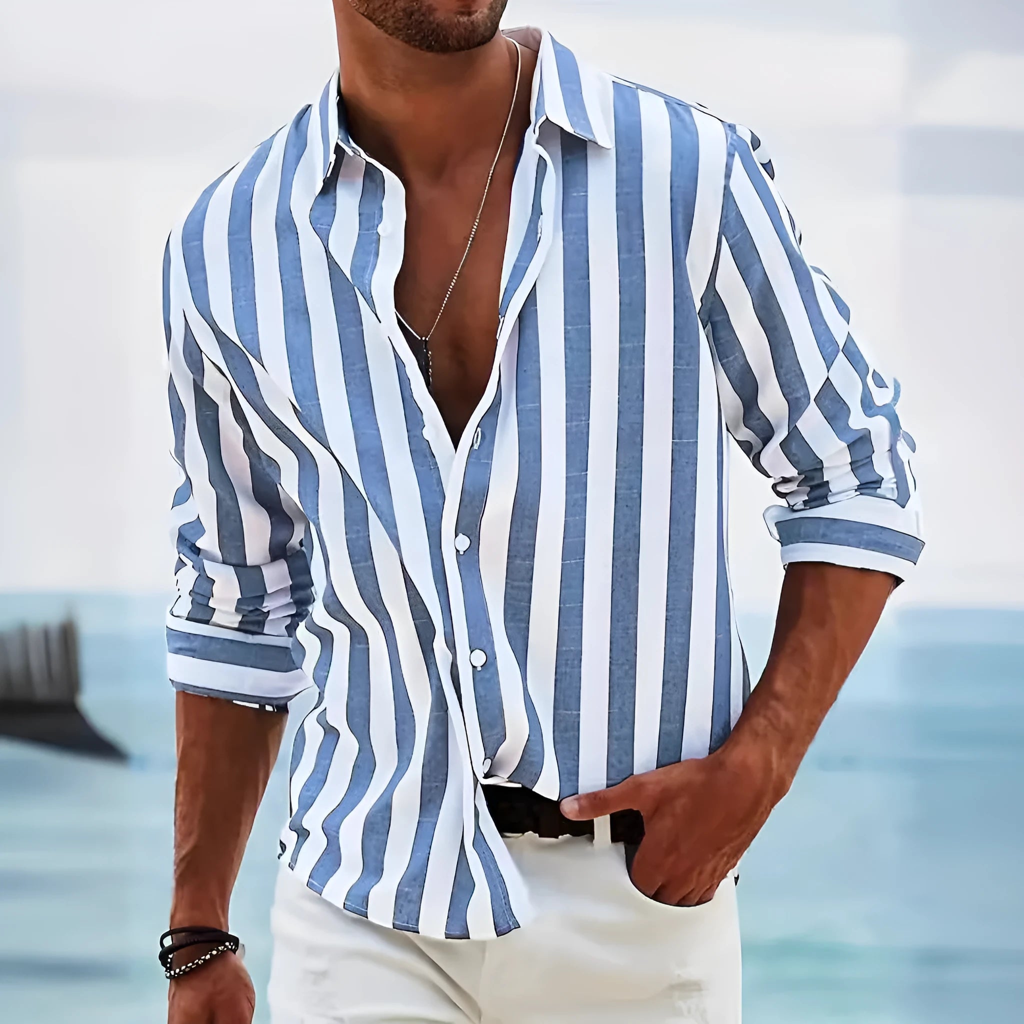 Man wearing a loose-fit, grey and white striped long-sleeved cardigan-style shirt.